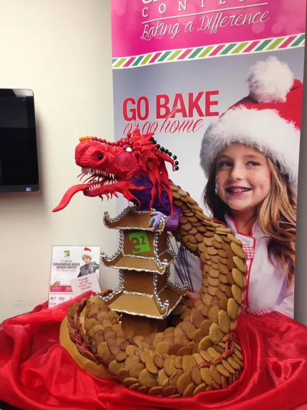 Red gingerbread dragon coiled around a tiered pagoda, in front of a Go Bake poster