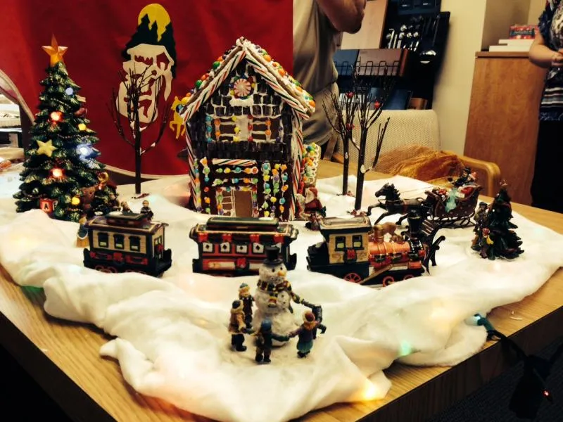 Snowy village display with a gingerbread house, candy train cars and a horse-drawn sleigh