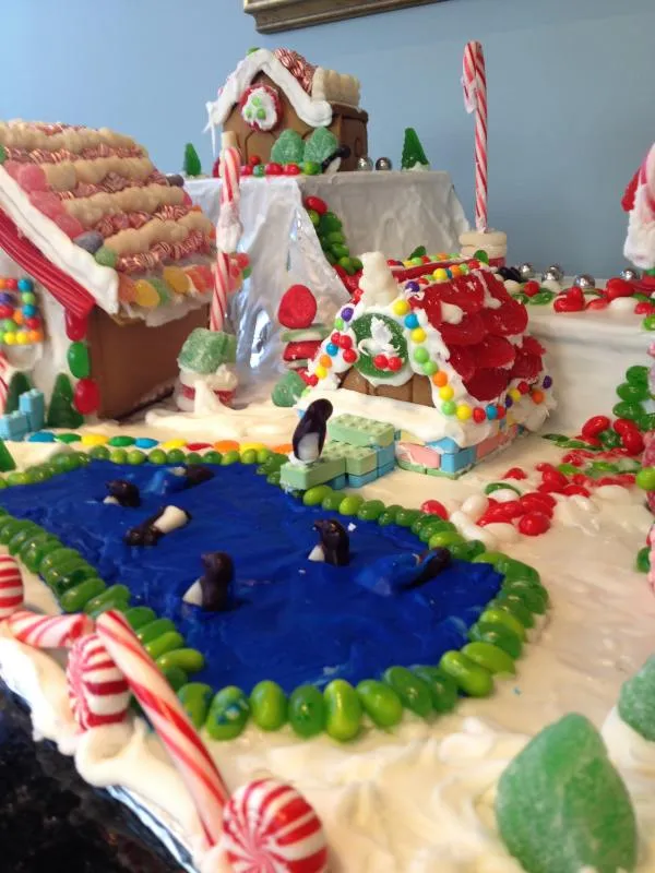 Gingerbread village scene with a blue icing pond, candy skaters and candy-cane fence