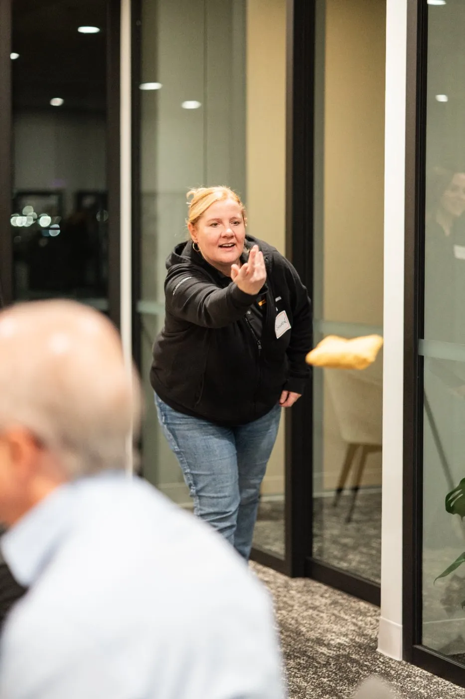 A guest smiling and waving as she walks into the reception